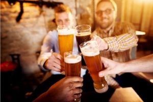 Friends cheers-ing a beer at a brewery