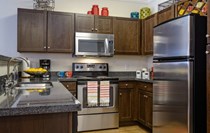 Gorgeous dark wood cabinets provide abundant storage, granite counter tops, stainless steel appliances, and built in wine rack.